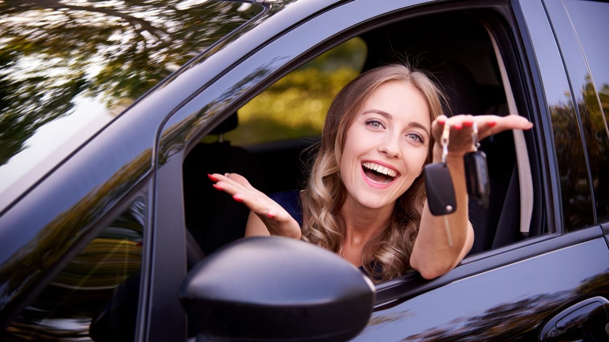Teenage girl holding keys outside of car window